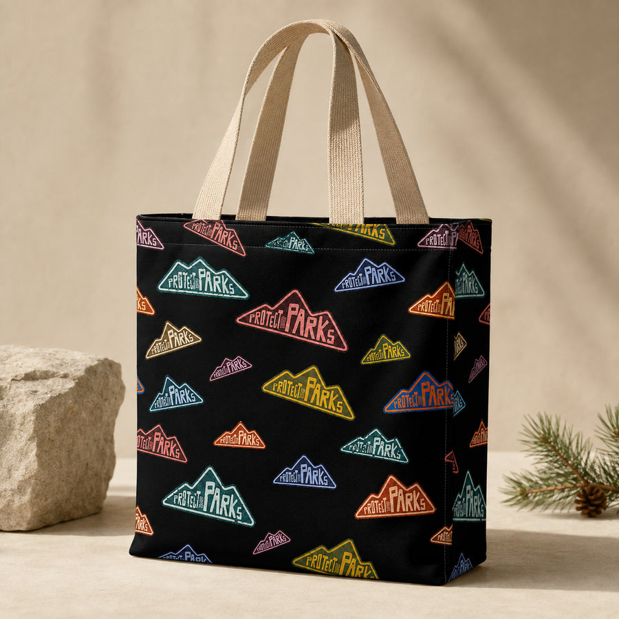 Protect Our Parks black all-over-print tote — beige handle hero