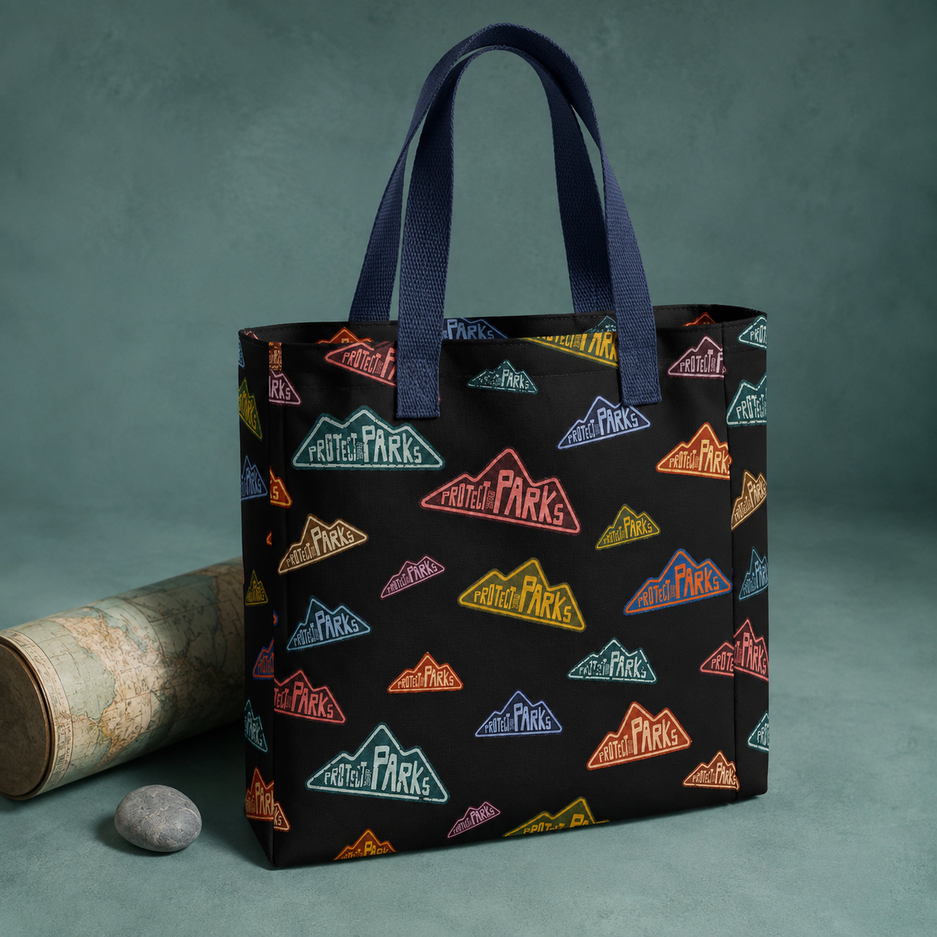 Protect Our Parks black all-over-print tote — navy handle angled product