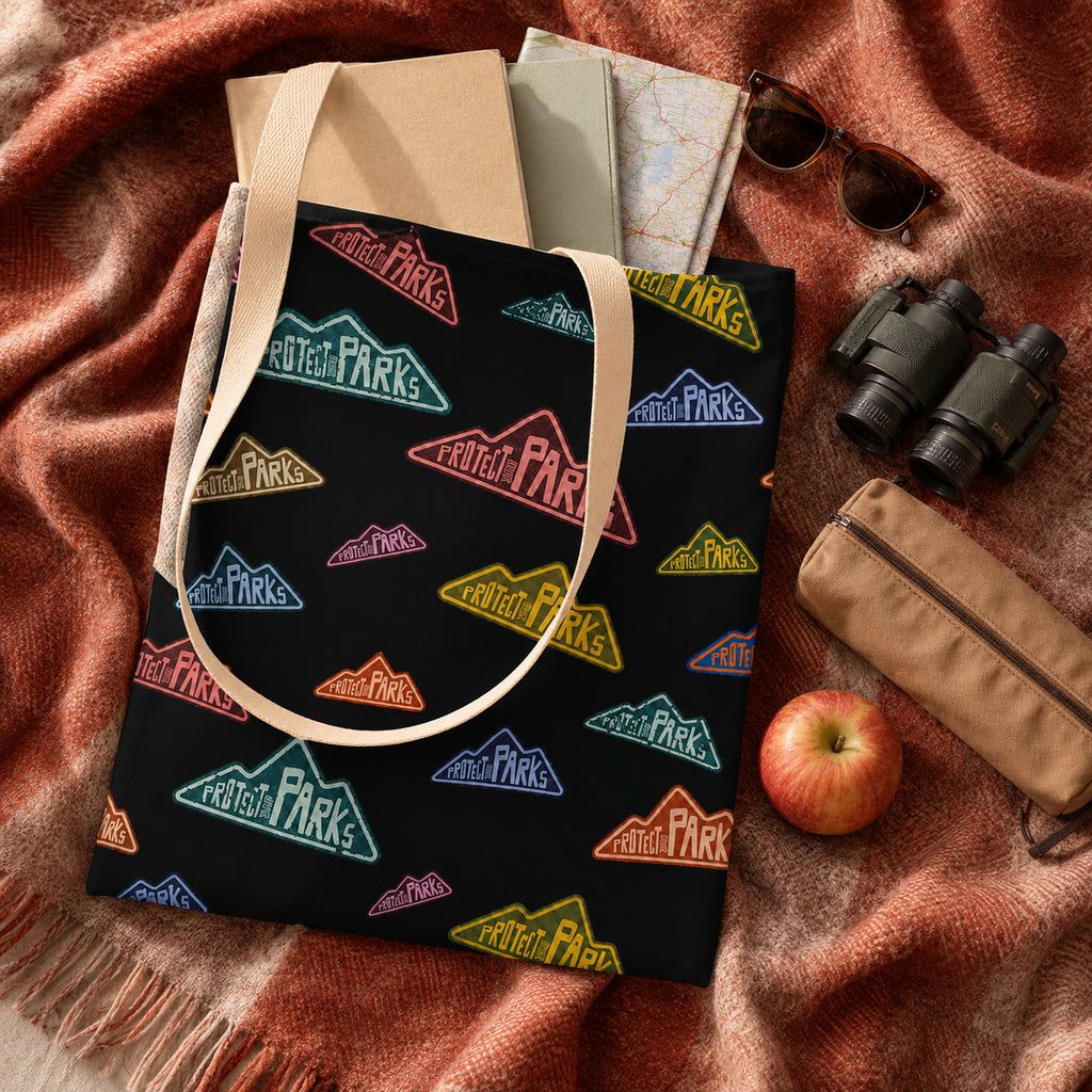 Protect Our Parks black all-over-print tote — library roadtrip flat lay